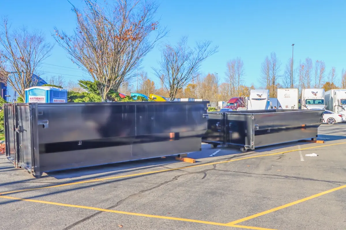 Professional dumpster rental service with roll-off container on residential driveway in Little Silver